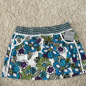 Athleta skirt with island print, white piping pockets & snap back pocket Size L